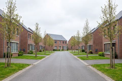 Hallennes-lez-Haubourdin : rue résidentielle de maisons en brique avec pelouses (image générée par IA)