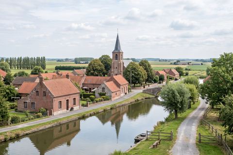 Hantay : village en brique avec église et chemin le long du canal (image générée par IA)