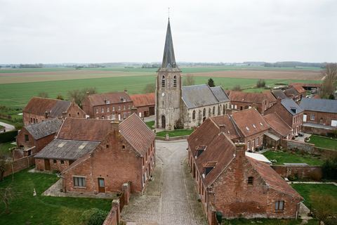 Illies : maisons de village autour d’une église à haute tour (image générée par IA)