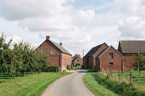 Le Maisnil : fermes en brique, granges et vergers (image générée par IA)